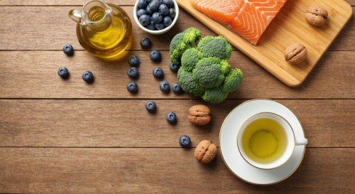 A photorealistic overhead view of a wooden table with a variety of fresh, colorful fruits and vegetables: blueberries, broccoli, walnuts, salmon fillet, olive oil bottle, and a cup of green tea. Natur