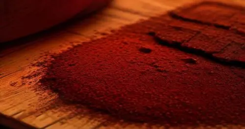 Photorealistic close-up of a rustic wooden table with a small pile of dark raw cocoa powder, scattered cocoa beans, and a piece of 90% dark chocolate, surrounded by fresh citrus slices and cinnamon st