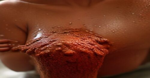 Close-up of a woman's underarm area with smooth, even-toned skin, applying a natural brown sugar and cocoa powder scrub by hand, warm bathroom lighting, spa setting, fotorrealistic, no text, no logos