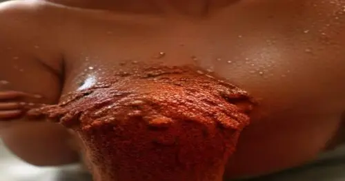 Close-up of a woman's underarm area with smooth, even-toned skin, applying a natural brown sugar and cocoa powder scrub by hand, warm bathroom lighting, spa setting, fotorrealistic, no text, no logos