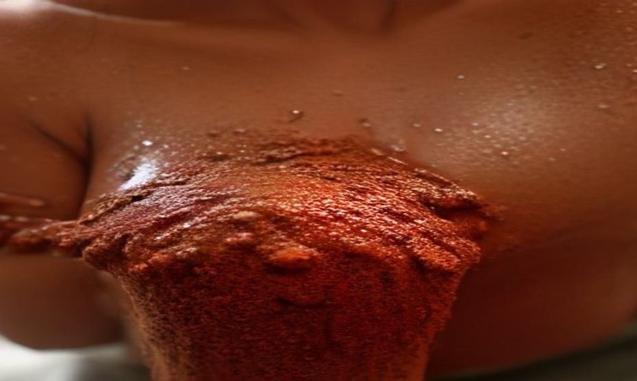 Cacao para aclarar axilas: protocolo natural casero 1 Close-up of a woman's underarm area with smooth, even-toned skin, applying a natural brown sugar and cocoa powder scrub by hand, warm bathroom lighting, spa setting, fotorrealistic, no text, no logos