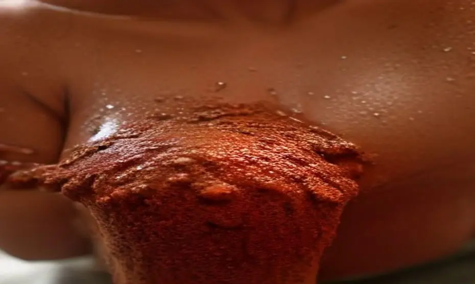 Close-up of a woman's underarm area with smooth, even-toned skin, applying a natural brown sugar and cocoa powder scrub by hand, warm bathroom lighting, spa setting, fotorrealistic, no text, no logos